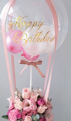 20 pink flowers and pink ribbons holding a hot air balloon with print happy birthday