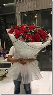 3 to 4 Feet of red roses in a life size bouquet wrapped in white paper