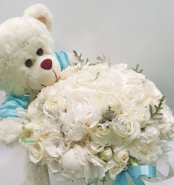 Blue 6 inches Teddy bear in a basket of 15 white roses