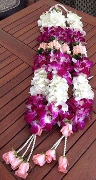 2 Garlands with beads on neck and bottom of white and purple orchids and pink roses at the end